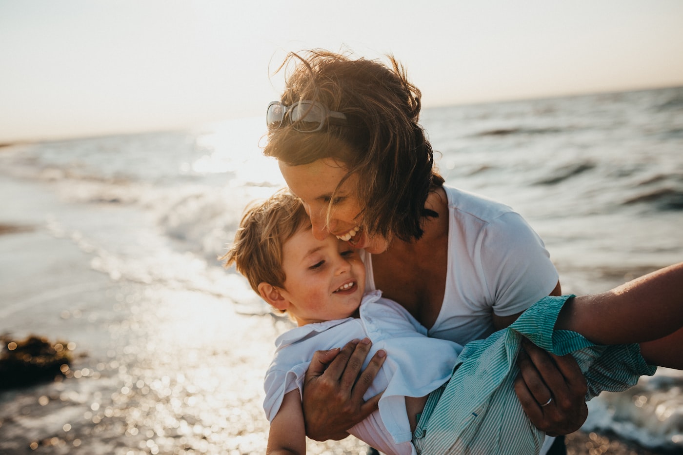 Mother embracing her child by the water